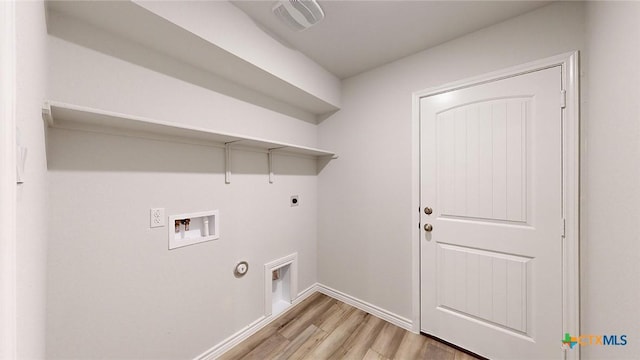 laundry room featuring gas dryer hookup, hookup for a washing machine, light hardwood / wood-style flooring, and electric dryer hookup