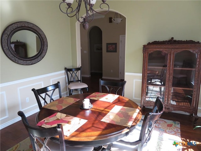 dining area with dark hardwood / wood-style flooring and a notable chandelier