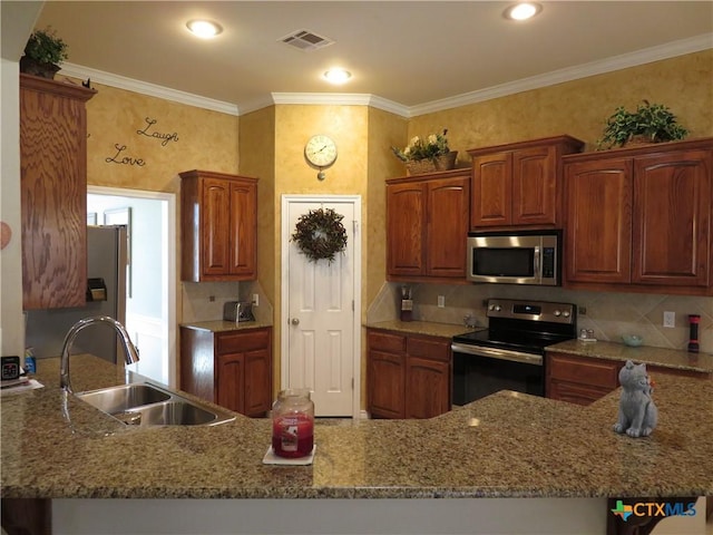 kitchen with appliances with stainless steel finishes, kitchen peninsula, sink, and light stone countertops