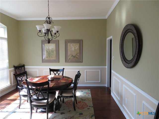 dining space featuring crown molding, dark wood-type flooring, and a chandelier