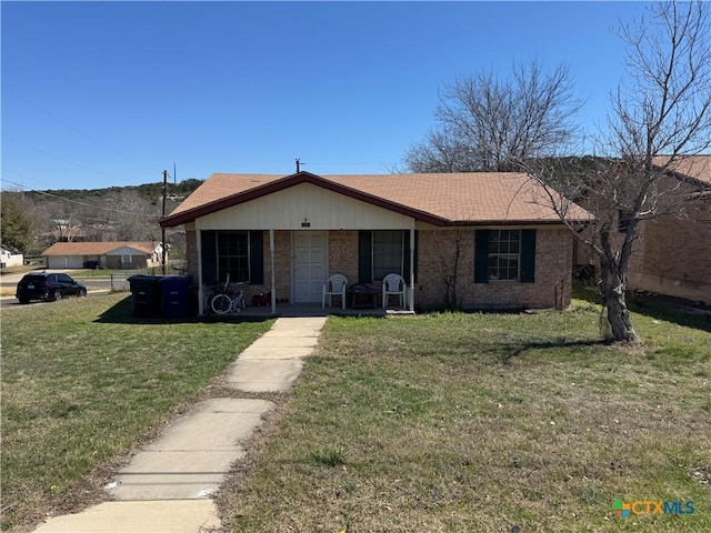 view of front facade with a front yard and brick siding