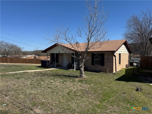 single story home featuring a front lawn, fence, and brick siding