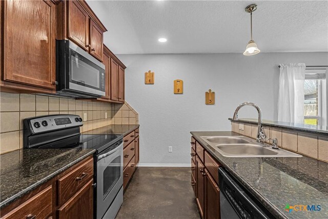 kitchen with tasteful backsplash, finished concrete flooring, baseboards, appliances with stainless steel finishes, and a sink