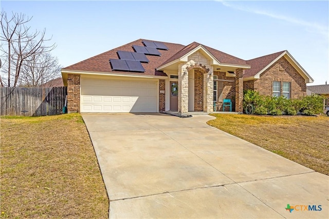 view of front facade with brick siding, a front lawn, and fence