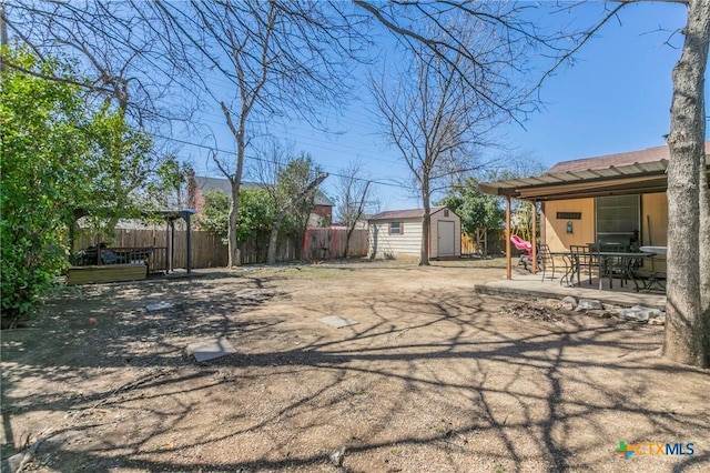 view of yard with a patio area, an outdoor structure, fence, and a shed