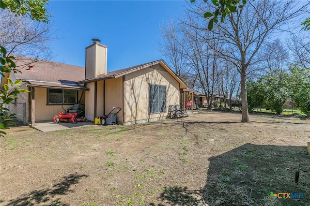 back of property featuring a patio area and a chimney