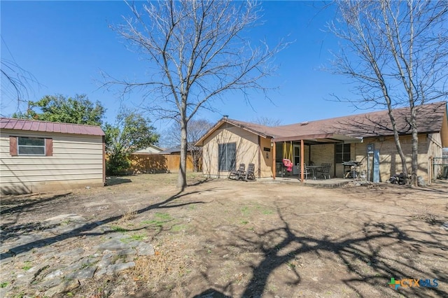 rear view of property featuring a patio area and fence