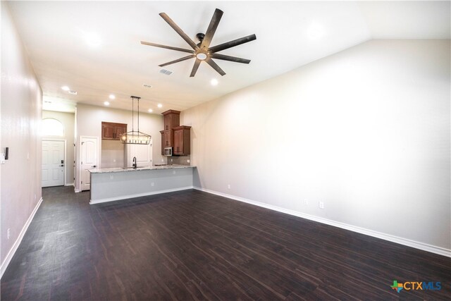 unfurnished living room with vaulted ceiling, ceiling fan, sink, and dark hardwood / wood-style flooring