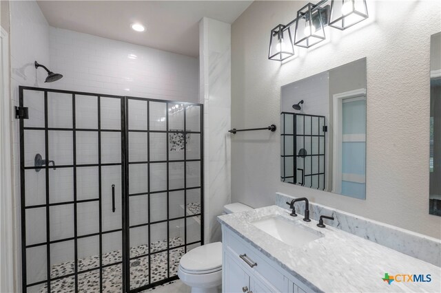 bathroom featuring vanity, toilet, and tiled shower