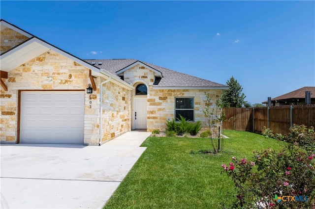 view of front of house featuring a garage and a front lawn