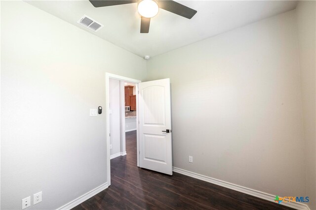 unfurnished room featuring dark hardwood / wood-style floors and ceiling fan