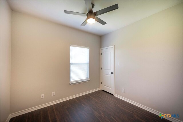 spare room with dark hardwood / wood-style floors and ceiling fan