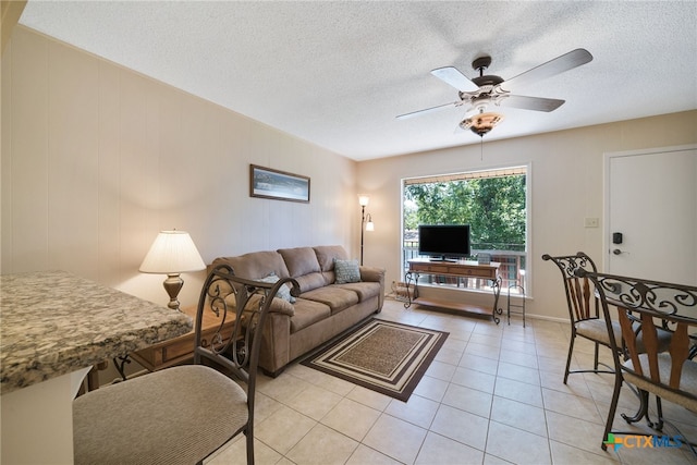 tiled living room featuring a textured ceiling and ceiling fan