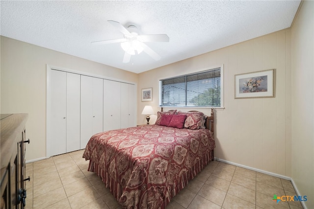 bedroom with a closet, a textured ceiling, light tile patterned floors, and ceiling fan