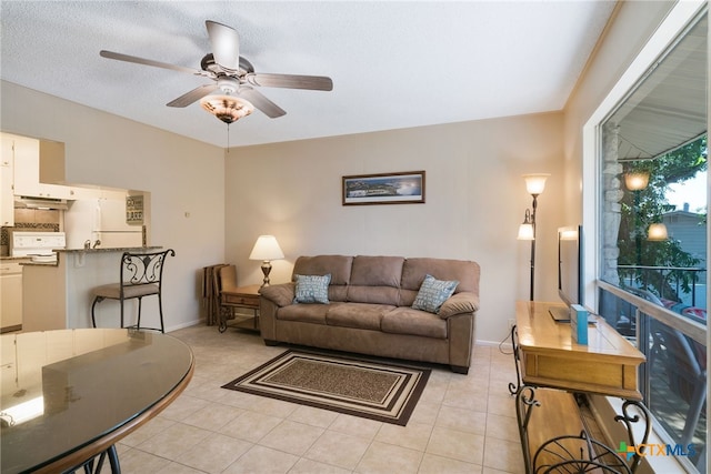 tiled living room with ceiling fan and a textured ceiling