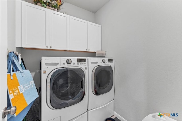 washroom with cabinets and washer and dryer