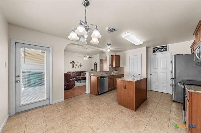 8003 Bridgepointe Dr, Temple, TX 76502 - kitchen featuring stainless steel appliances, a peninsula, arched walkways, open floor plan, and visible vents