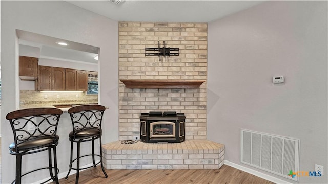 living room featuring light wood-type flooring and a wood stove