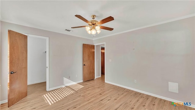 empty room featuring ceiling fan, light wood-type flooring, and crown molding