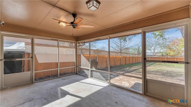 unfurnished sunroom featuring ceiling fan