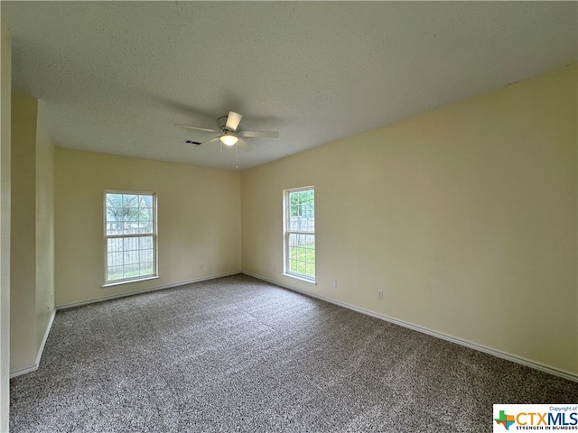 unfurnished room with a textured ceiling, carpet floors, and ceiling fan