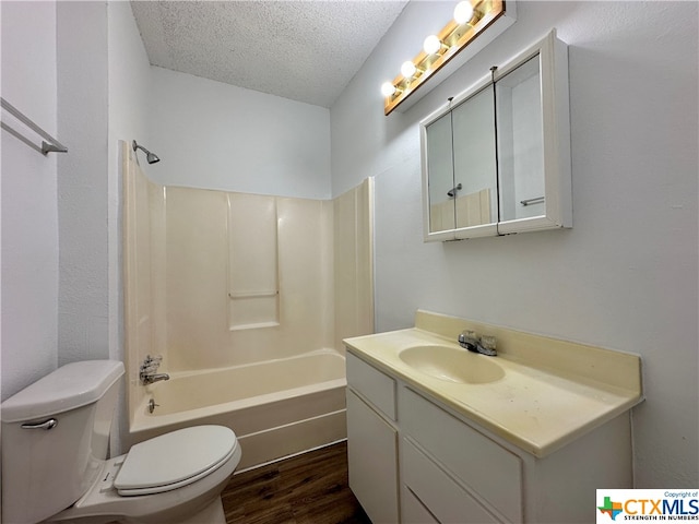 full bathroom with toilet,  shower combination, a textured ceiling, vanity, and hardwood / wood-style flooring