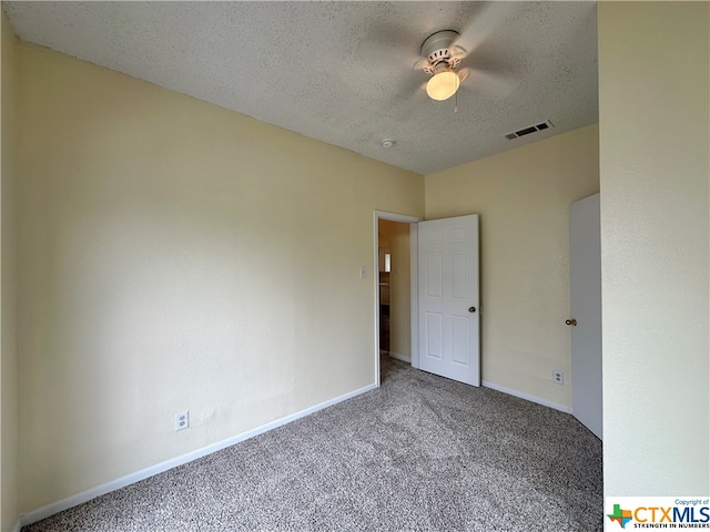 unfurnished room with ceiling fan, a textured ceiling, and carpet