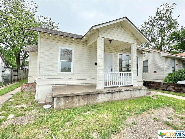 view of front of home with covered porch and a front yard