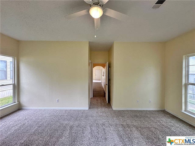 empty room featuring ceiling fan, a textured ceiling, and carpet flooring