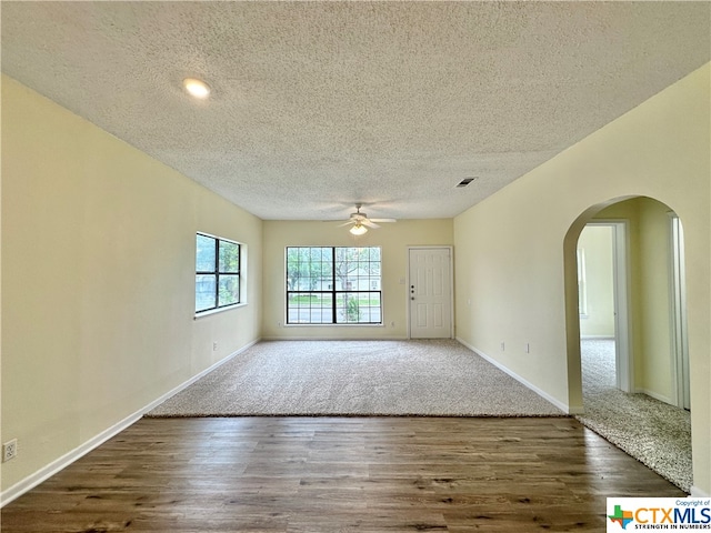 unfurnished room with ceiling fan, dark hardwood / wood-style floors, and a textured ceiling