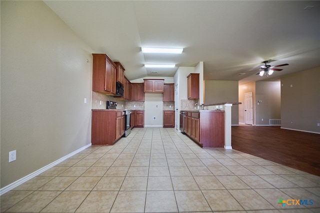 kitchen featuring stainless steel appliances, ceiling fan, tasteful backsplash, and light tile patterned floors