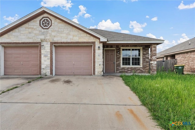 ranch-style house featuring an attached garage, fence, driveway, and stone siding