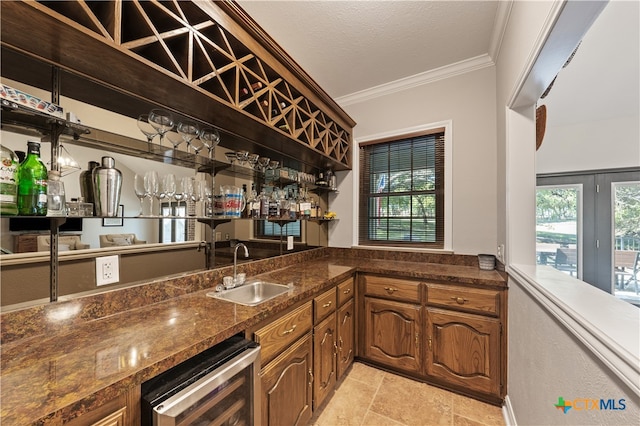 bar with ornamental molding, wine cooler, a textured ceiling, sink, and dark stone countertops