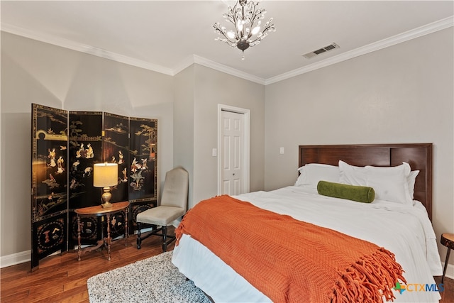 bedroom with wood-type flooring, an inviting chandelier, and crown molding