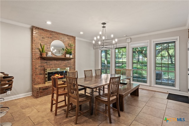 dining space with a brick fireplace, ornamental molding, and a notable chandelier