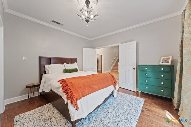 bedroom featuring a notable chandelier, dark hardwood / wood-style floors, and crown molding