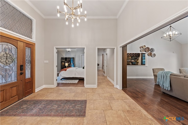 foyer entrance with a towering ceiling, crown molding, and light hardwood / wood-style flooring