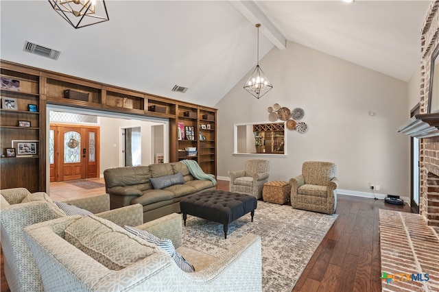 living room with a fireplace, wood-type flooring, beam ceiling, and an inviting chandelier