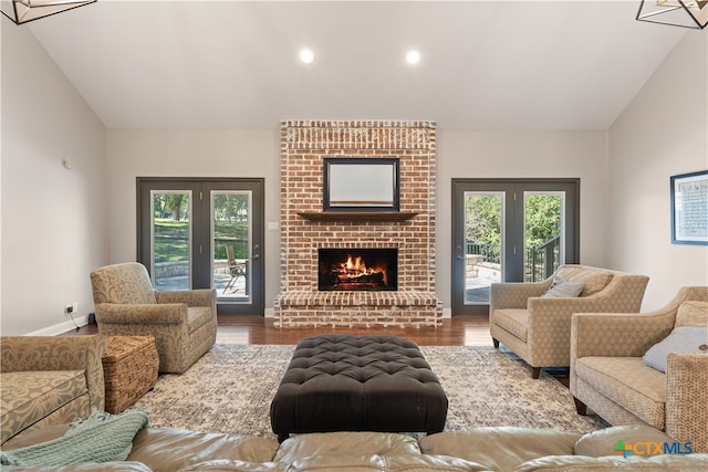 living room featuring lofted ceiling, hardwood / wood-style floors, and a healthy amount of sunlight