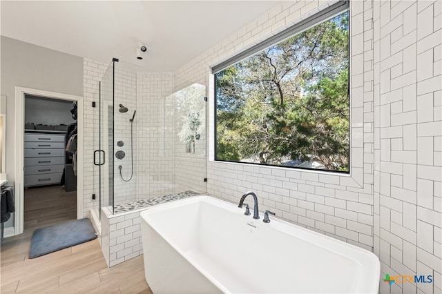 bathroom with plus walk in shower, hardwood / wood-style flooring, and a healthy amount of sunlight