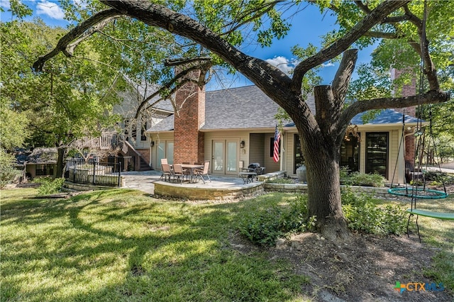 rear view of property with a patio area, a yard, and french doors