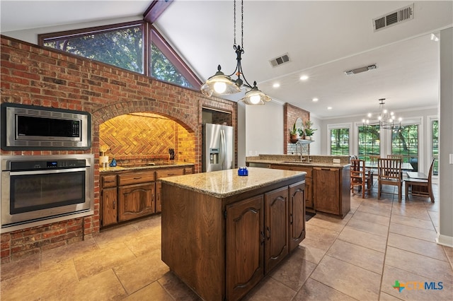 kitchen featuring appliances with stainless steel finishes, hanging light fixtures, a center island, and plenty of natural light