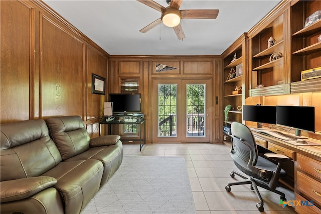 home office with ceiling fan, built in features, wooden walls, and light tile patterned floors