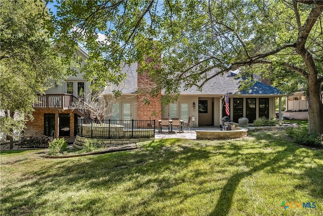 back of house featuring a yard, french doors, and a patio area