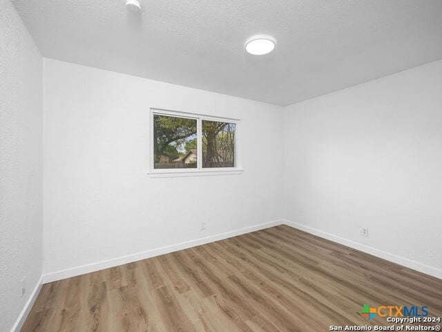 spare room with wood-type flooring