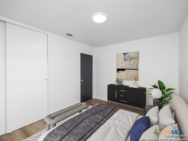 bedroom with hardwood / wood-style flooring and a closet