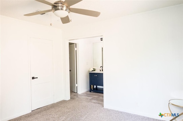 1004 Buena Vista Ave, Victoria, TX 77901 - unfurnished bedroom with light carpet, a sink, ceiling fan, and connected bathroom