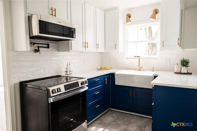 1004 Buena Vista Ave, Victoria, TX 77901 - kitchen with appliances with stainless steel finishes, blue cabinetry, a sink, and white cabinetry