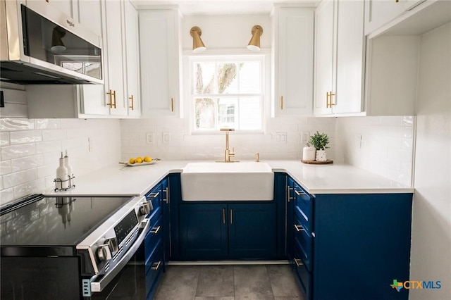 1004 Buena Vista Ave, Victoria, TX 77901 - kitchen with blue cabinetry, appliances with stainless steel finishes, a sink, and decorative backsplash