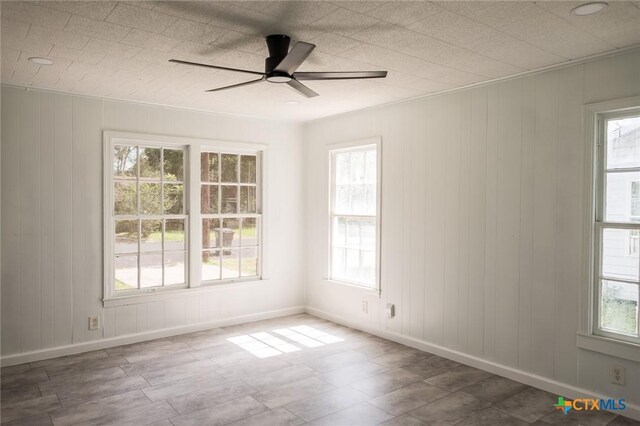 1004 Buena Vista Ave, Victoria, TX 77901 - unfurnished room featuring healthy amount of natural light, baseboards, ceiling fan, and wood walls